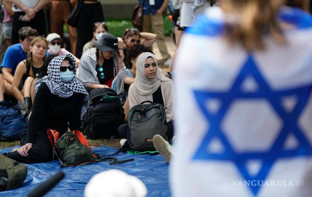 $!Un estudiante envuelto en una bandera israelí escucha a los manifestantes pro palestinos reunidos en el campus de la Universidad de Texas en Austin.