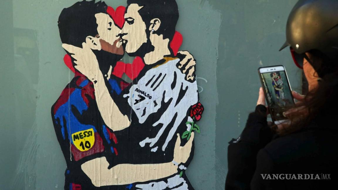 Leo Messi y Cristiano Ronaldo se dan un beso en un grafiti