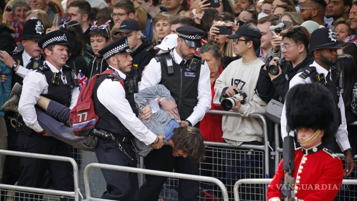$!Policías retiran a un hombre que corrió en la ruta de la procesión real en el paseo The Mall en Londres antes del Desfile del Estandarte.