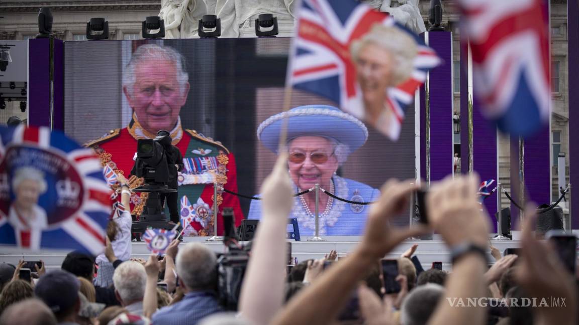 $!Personas en un centro comercial observa a Su Majestad, la Reina y el Príncipe de Gales en el balcón del Palacio de Buckingham en una pantalla gigante.