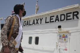 Un soldado hutí observa el barco Galaxy Leader, de bandera israelí, el cual fue capturado y ahora es mantenido en un puerto yemení.