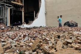 Un hombre camina entre ladrillos caídos de un edificio dañado después de una fuerte tormenta en Houston.