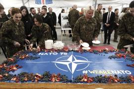 Los soldados cortan rebanadas de un pastel de celebración durante una ceremonia que conmemora el 75º aniversario de la OTAN en la base militar de Adazi, cerca de Riga, en Letonia.