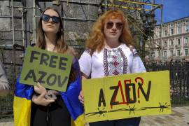 Olga Bielous (i) y Victoria Velihura, compañera de clase y esposa, respectivamente, de combatientes ucranianos prisioneros, participan en un acto de apoyo a las familias de los prisioneros de guerra en Kiev.