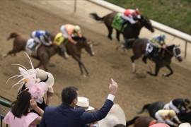 La gente reacciona mientras ve una carrera de caballos en Churchill Downs el sábado 6 de mayo de 2023 en Louisville, Ky.