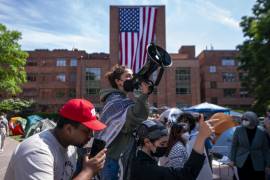 Activistas pro palestinos reaccionan ante el despliegue de una gran bandera estadounidense en el campamento de manifestantes en la Universidad George Washington (GWU) en Washington, DC.