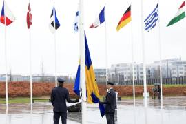 Dos militares se preparan para izar la bandera de Suecia en una ceremonia para conmemorar la entrada del país en la OTAN, en la sede de la Organización del Tratado del Atlántico Norte