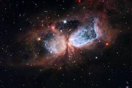 Un ángel navideño del telescopio Hubble, Sharpless 2-106, con “alas” que son lóbulos gemelos de gas supercaliente que se extienden hacia afuera desde la estrella central.