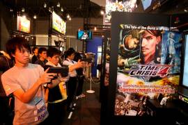 Aficionados japoneses a los videojuegos juegan con el Time Crisis 4 del fabricante Bandai Namco.