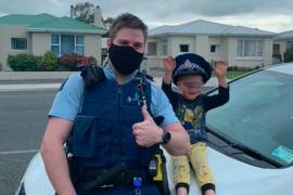 En esta foto divulgada por la Policía de Nueva Zelanda, un oficial identificado solo como Constable Kurt está sentado en su patrulla con un niño de 4 años que no está identificado, en la ciudad de Invercargill, en la Isla Sur, Nueva Zelanda. AP/NZ Police