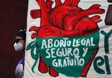 Una mujer sostiene una pancarta que dice “Aborto legal, seguro y gratuito mientras manifestantes por el derecho al aborto se manifiestan frente al Congreso.