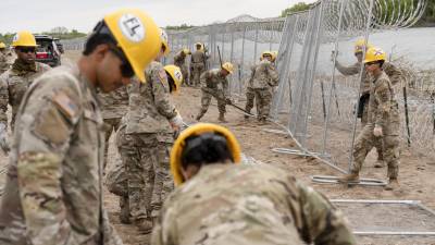 Miembros de la Guardia Nacional de Florida instalan cercas temporales cubiertas con alambre de púas a lo largo del río Bravo cerca de Eagle Pass, Texas, el 19 de marzo de 2024.