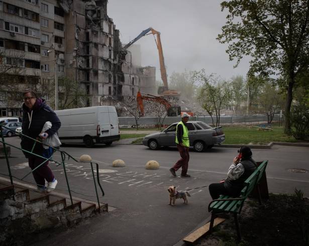 Un grupo de personas pasa por delante de un edificio dañado en Járkov, Ucrania, una ciudad que sufre ataques casi a diario.