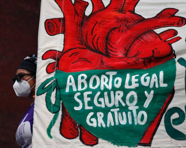 Una mujer sostiene una pancarta que dice “Aborto legal, seguro y gratuito mientras manifestantes por el derecho al aborto se manifiestan frente al Congreso.