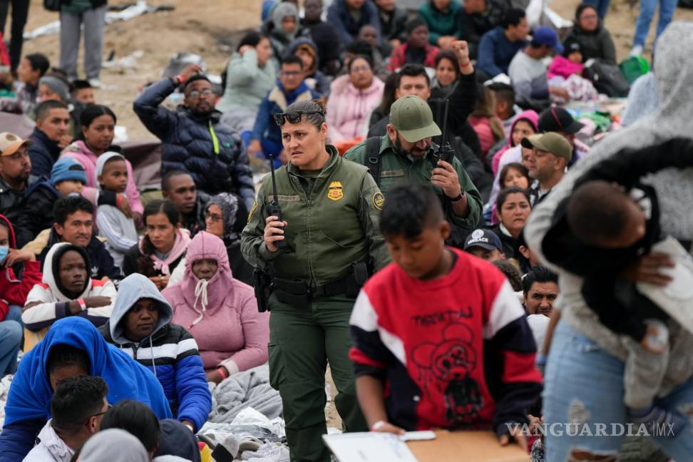 $!Agentes de la Patrulla Fronteriza entre una multitud de migrantes que han esperado entre dos muros fronterizos durante días para solicitar asilo en San Diego.