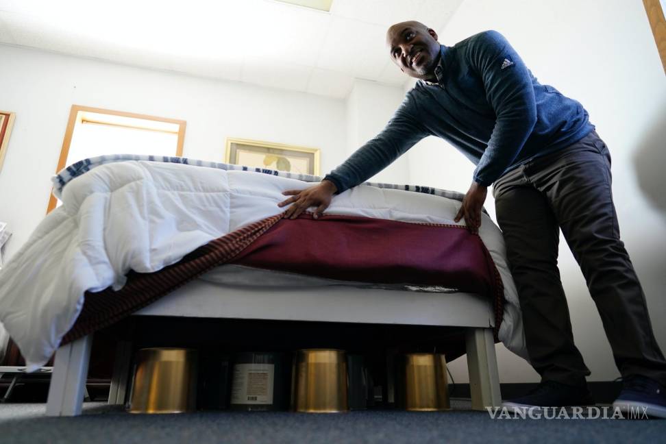 $!Seth Robinson, quiropráctico que dirige la clínica de Tesla BioHealing, levanta las sábanas de una cama para mostrar los biosanadores.