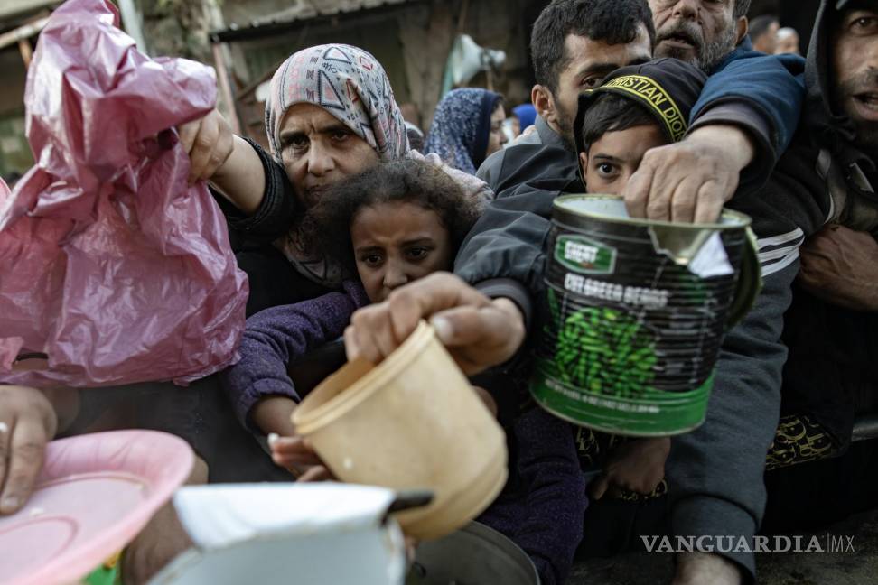 $!Palestinos desplazados se reúnen para recoger alimentos donados por un grupo benéfico antes del desayuno, el cuarto día del mes sagrado del Ramadán en Rafah.