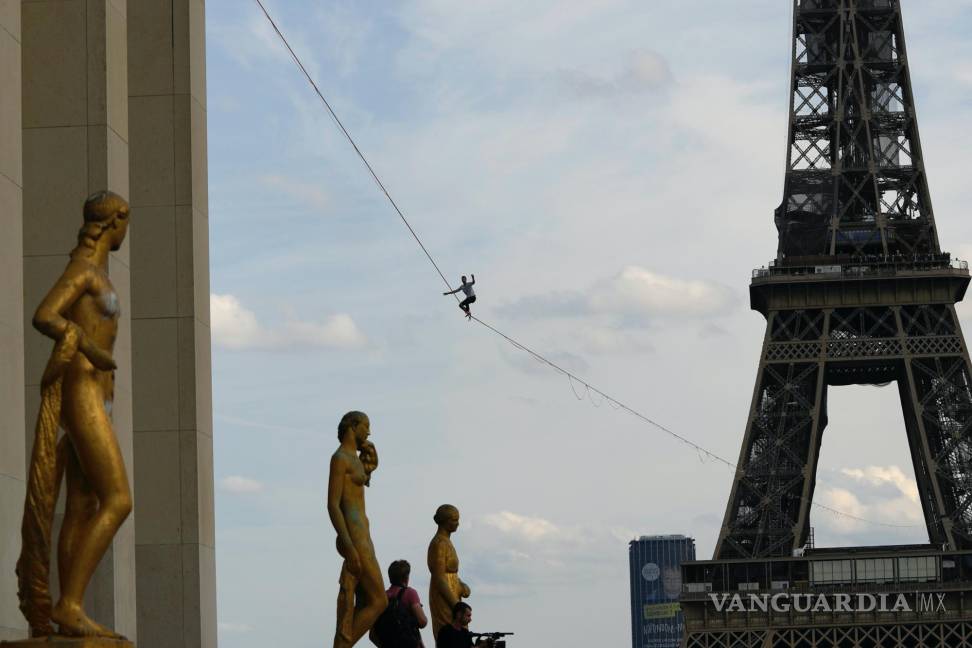 $!El slackliner francés Nathan Paulin actúa por segunda vez en un slackline de 70 metros de altura entre la Torre Eiffel y el Teatro Chaillot al otro lado del río Sena, en París. AP/Francois Mori
