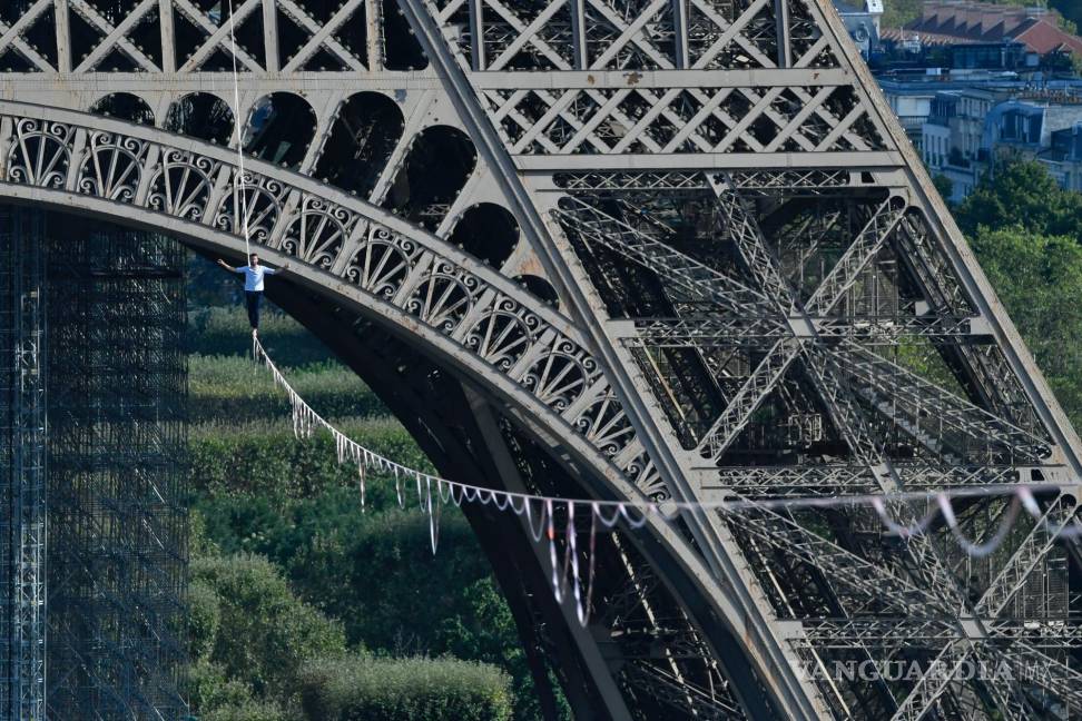 $!El acróbata francés Nathan Paulin camina por una línea alta desde la Torre Eiffel a través del río Sena, como parte de los eventos en Francia para los Días del Patrimonio Nacional en París. AP/Alain Jocard