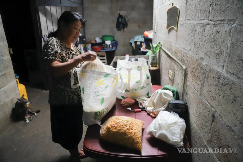 $!María Concepción Ventura prepara un paquete para su hija Juana Guadalupe Recinos, una madre soltera de dos hijos que está en la cárcel, en Santa Ana.