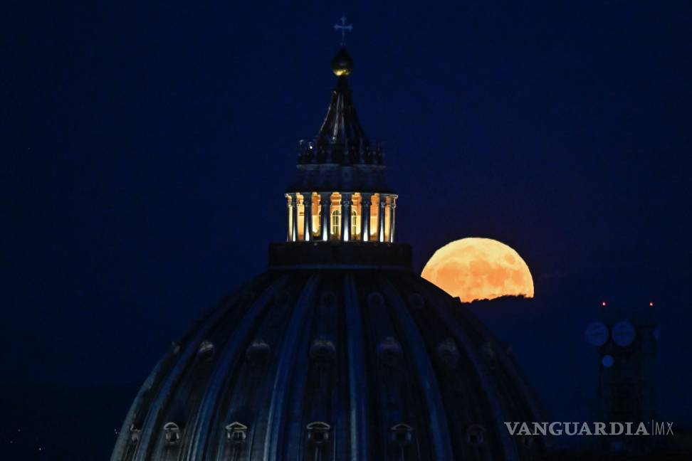 $!La Súper Luna llamada “Luna del Ciervo” se eleva en el cielo detrás de la cúpula de la Basílica de San Pedro en la Ciudad del Vaticano vista desde Roma, Italia.