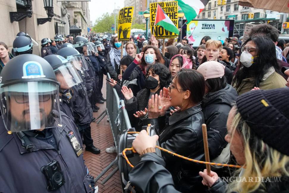 $!Agentes de policía de la ciudad de Nueva York hacen guardia mientras los manifestantes corean consignas frente al campus de la Universidad de Columbia.