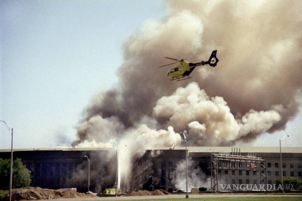 $!Un helicóptero vuela sobre el Pentágono en Washington mientras sale humo del edificio el 11 de septiembre de 2001, después de que un avión secuestrado fue estrellado en la parte oeste del edificio, matando a 184 personas.AP/Heesoon Yim