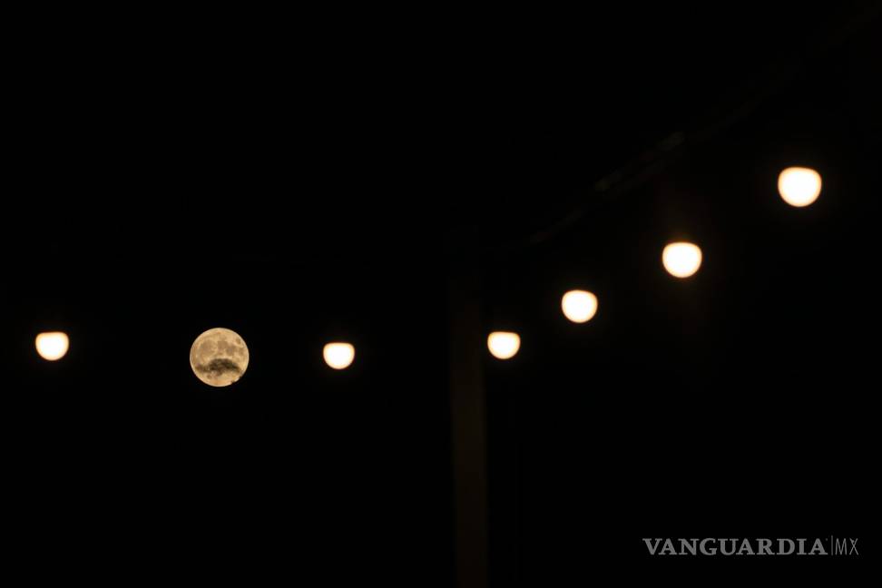 $!La superluna de Ciervo, entre farolas cerca de la localidad de Aegio, en el Peloponeso, Grecia, el 13 de julio de 2022.