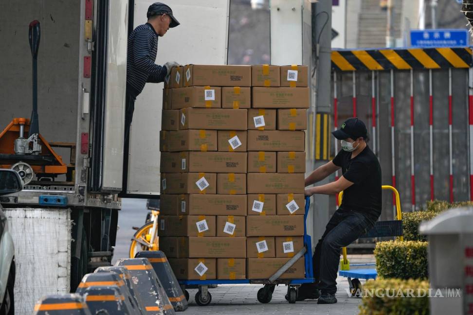 $!Los trabajadores descargan cajas que contienen carne congelada de un camión para un restaurante en un centro comercial en Beijing el 27 de febrero de 2023.