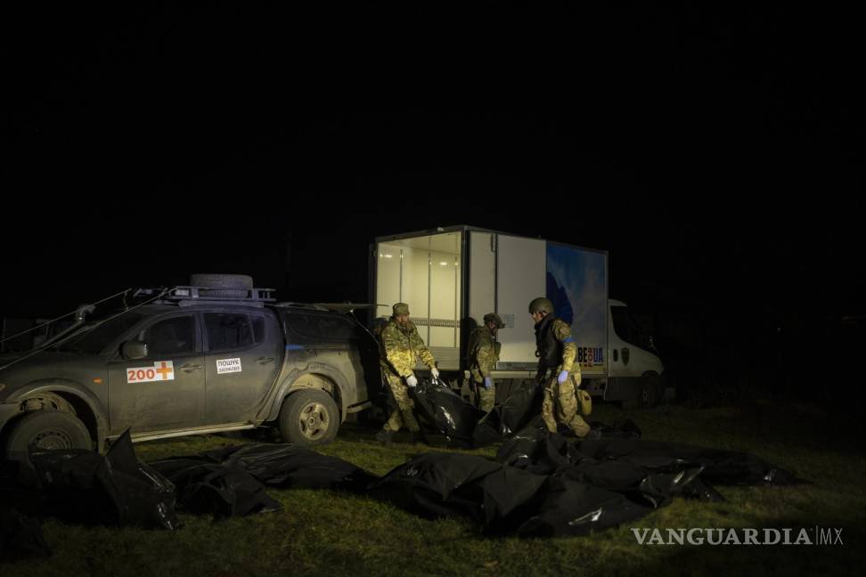 $!Los miembros del equipo de Oleksii Yukov descargan de su camioneta los cuerpos de los soldados rusos que han recogido en el frente en la región de Slaviansk.