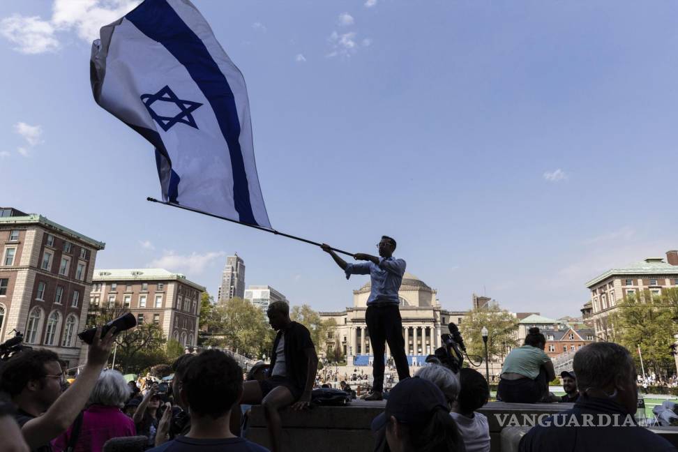 $!David Lederer, estudiante de segundo año de Columbia, ondea una gran bandera de Israel frente al campamento de protesta estudiantil en la Universidad de Columbia