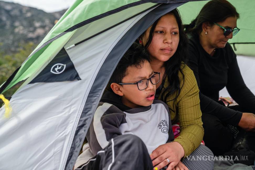 $!Michelle Cuenca, de Ecuador, y su hijo, Ezequiel Molina esperan a ser recogidos por agentes de la Patrulla Fronteriza en un campamento para solicitantes de asilo.