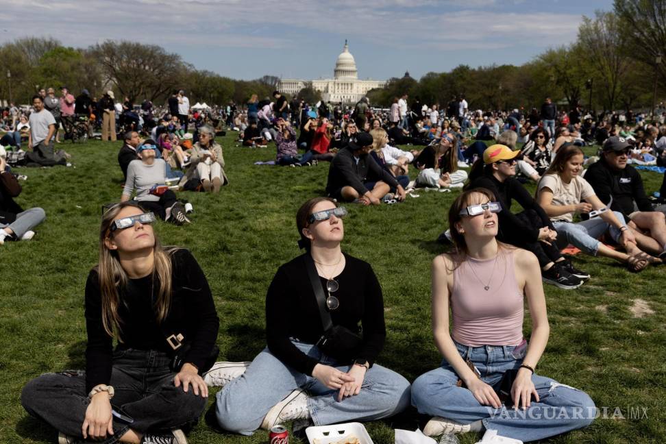 $!La gente en el National Mall observa un eclipse solar parcial, con el edificio del Capitolio de los Estados Unidos visto detrás, en Washington, DC.