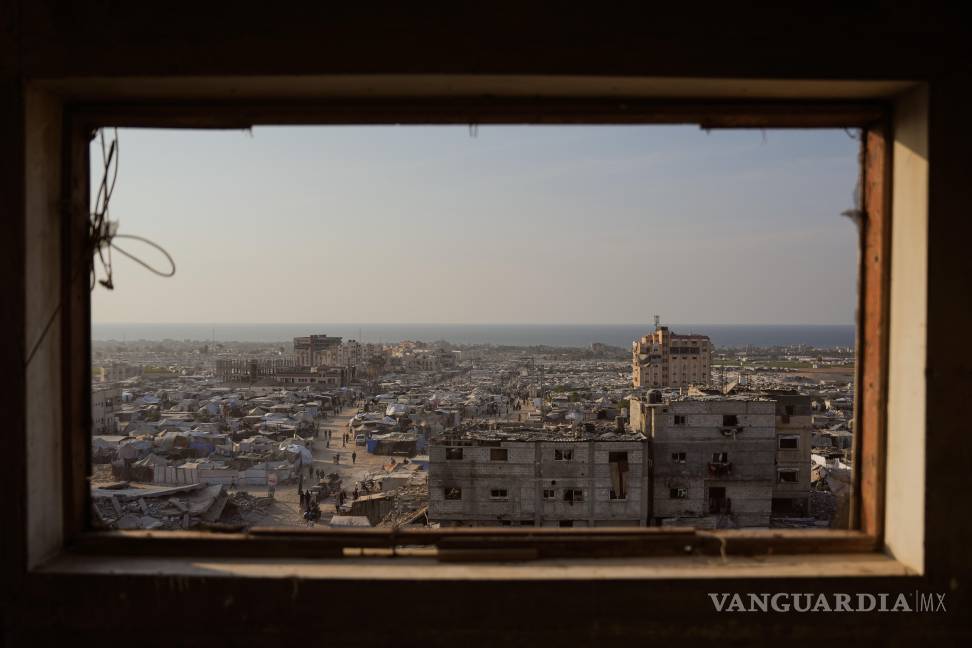 Palestinos desplazados caminan por un campamento improvisado de tiendas de campaña en la zona de Muwasi, en Jan Yunis, en la Franja de Gaza. $!Palestinos desplazados caminan por un campamento improvisado de tiendas de campaña en la zona de Muwasi, en Jan Yunis, en la Franja de Gaza.