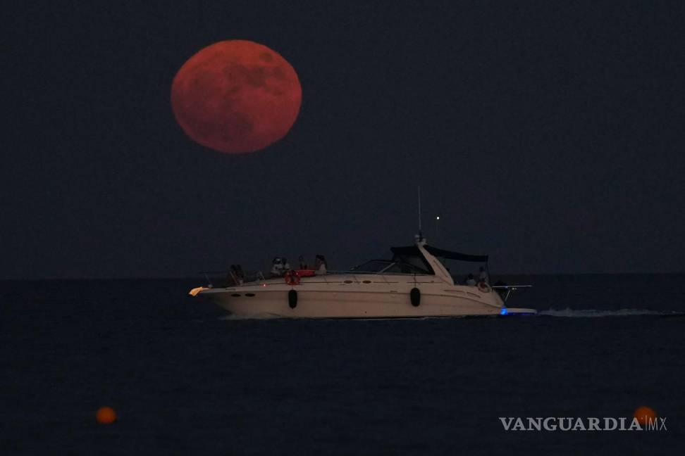 $!La luna llena se eleva sobre un barco en la ciudad mediterránea de Larnaca, en el sureste de Chipre, el 13 de julio de 2022.