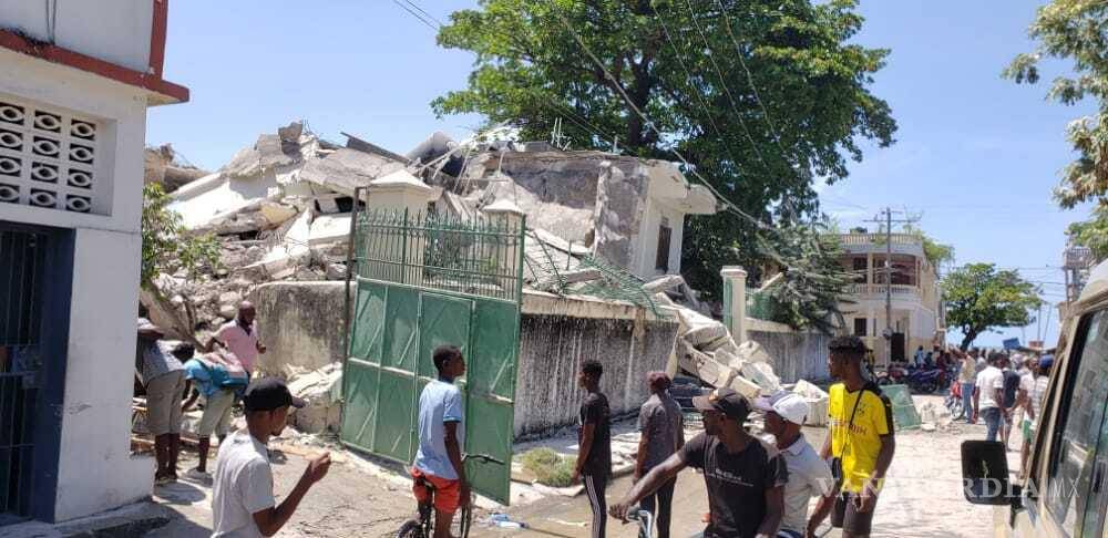 $!La gente se para frente a la residencia del obispo católico después de que fuera dañada por un terremoto en Les Cayes, Haití. AP/Delot Jean