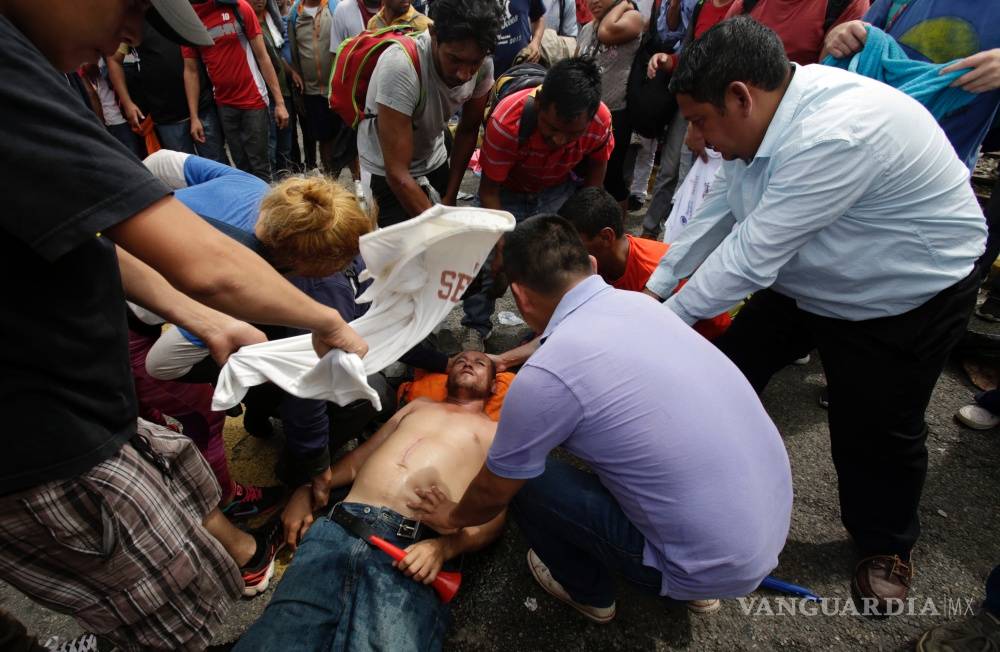 $!Caos y heridos, caravana migrante rompe cerco y cruza frontera con México (Fotogalería)