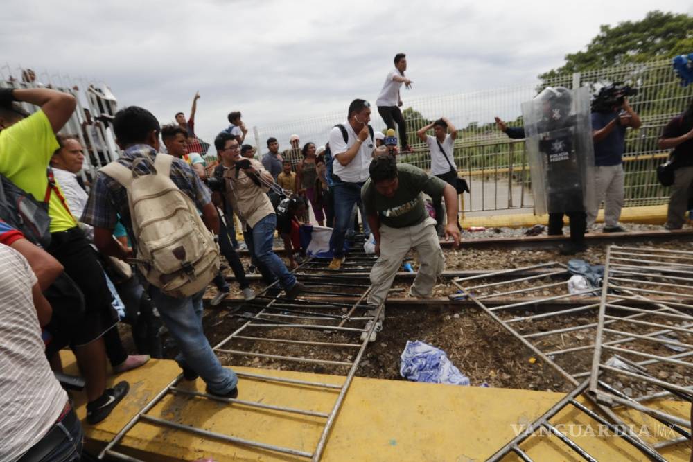 $!Caos y heridos, caravana migrante rompe cerco y cruza frontera con México (Fotogalería)