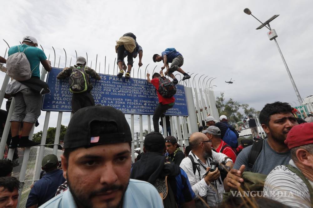 $!Caos y heridos, caravana migrante rompe cerco y cruza frontera con México (Fotogalería)