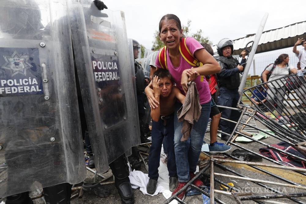 $!Caos y heridos, caravana migrante rompe cerco y cruza frontera con México (Fotogalería)