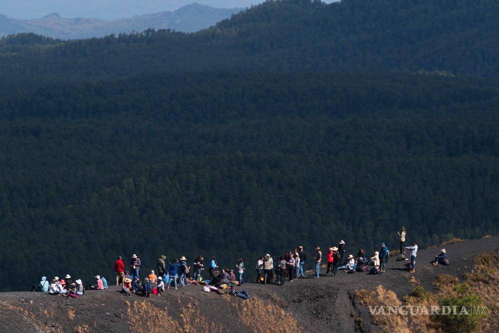 $!Un grupo de personas que forman parte de un congreso internacional de vulcanología descansa en el borde del cráter del volcán Paricutín, en Michoacán.