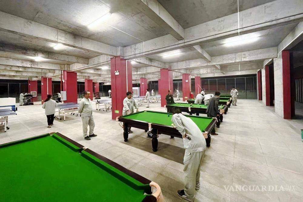 $!Trabajadores en la sala de billar en la granja de cerdos urbana de la empresa en las afueras de Ezhou, China.