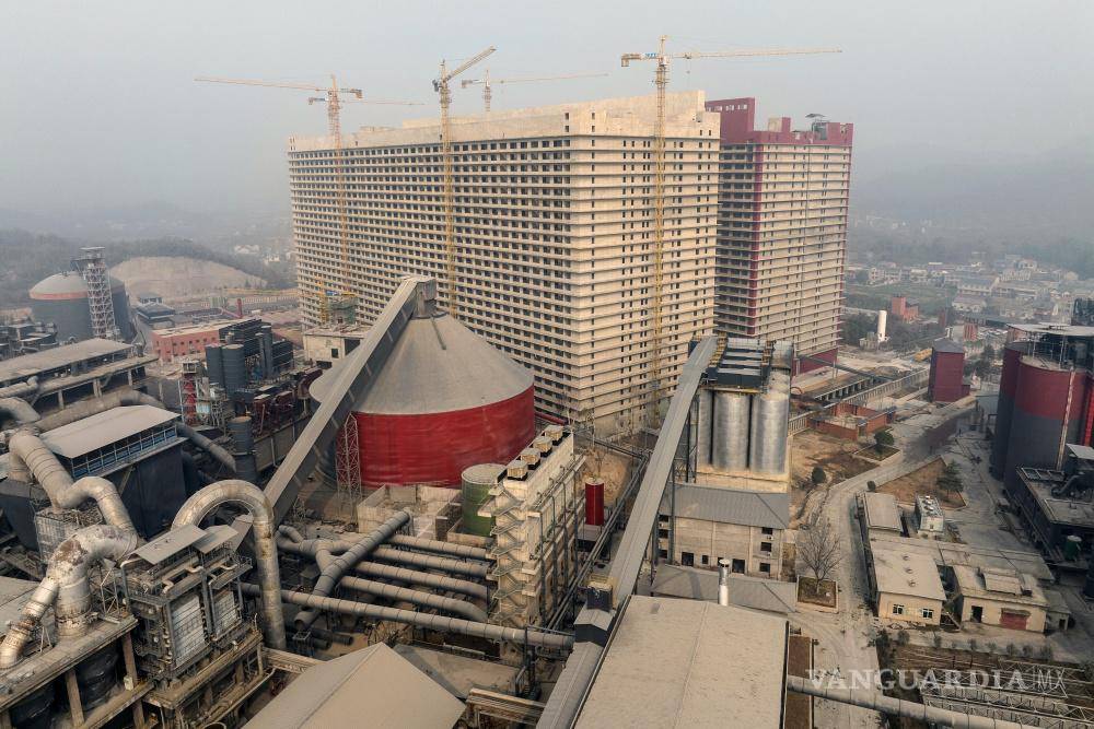 $!Un edificio de viviendas de 26 pisos y una granja de cerdos urbana en las afueras de Zhou, China.