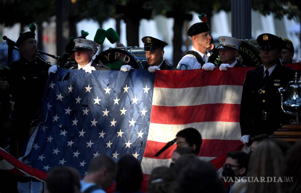 $!La policía y los bomberos de Nueva York sostienen una bandera de los Estados Unidos mientras una banda toca el Himno Nacional de EU en el Monumento Nacional del 11 de septiembre durante una ceremonia que conmemora el 20 aniversario de los ataques del 11 de septiembre en el World Trade Center, en Nueva York. EFE/EPA/Ed Jones