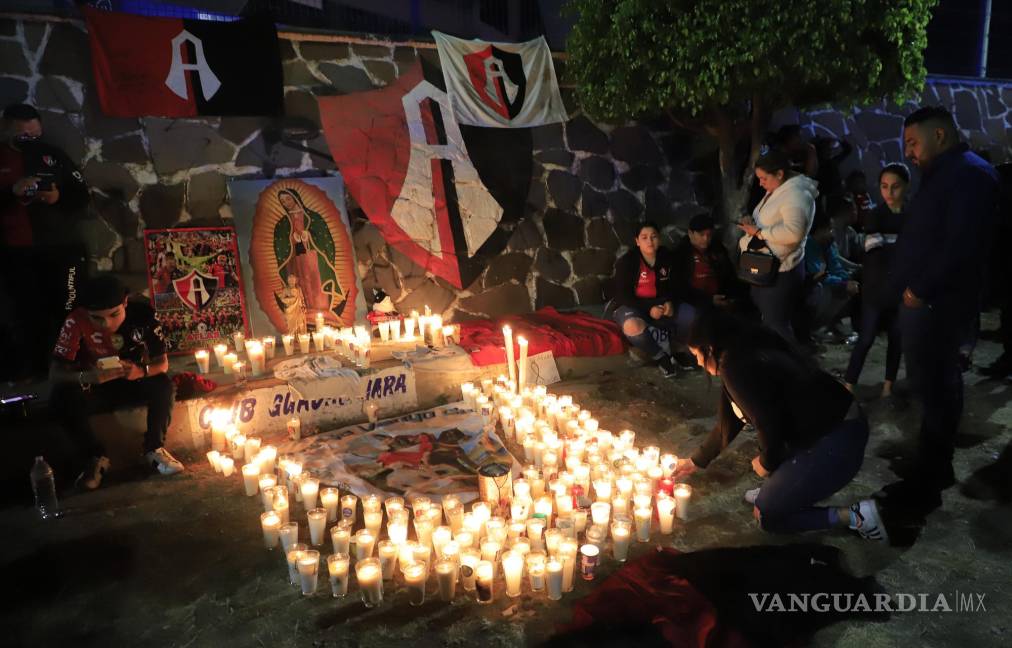 $!Aficionados del Club Atlas, encienden velas en la madrugada de este domingo, en las inmediaciones del estadio Jalisco, en la ciudad de Guadalajara, debido a los actos de violencia ocurridos en el partido.