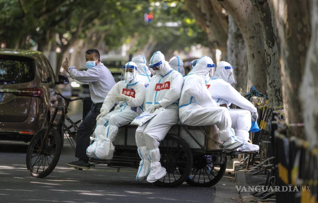$!Trabajadores médicos viajan en una bicicleta de carga, en Shanghái, China.