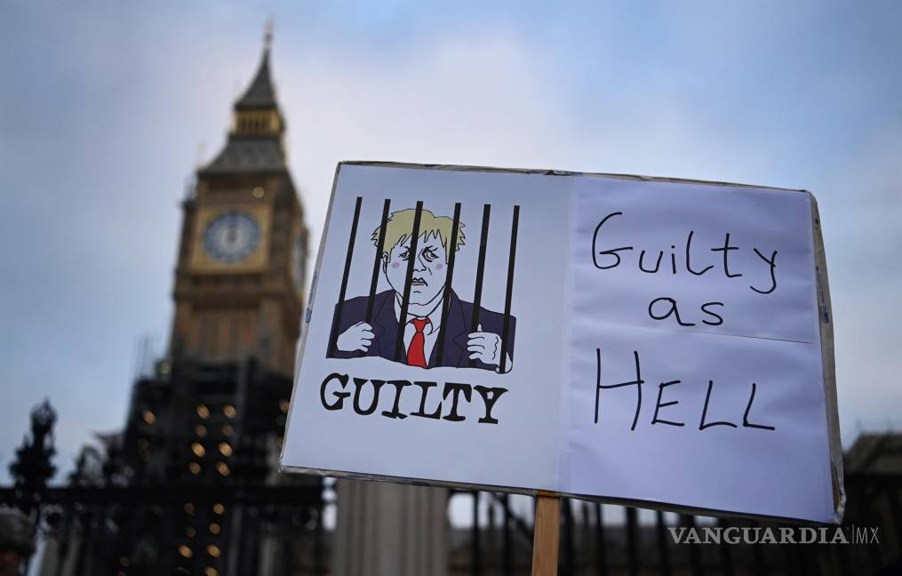 $!Un cartel que representa al primer ministro británico, Boris Johnson, tras las rejas frente al parlamento en Londres, Gran Bretaña. EFE/EPA/Andy Rain