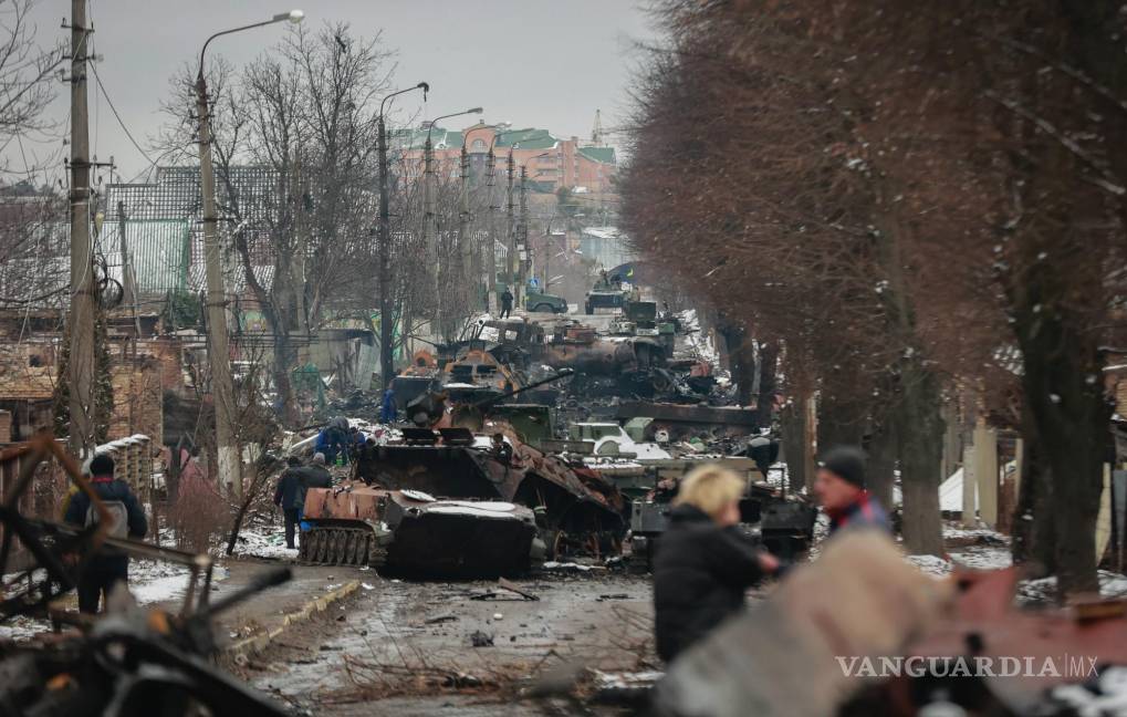 $!Varias personas observan los restos de vehículos militares rusos en una calle de la ciudad de Bucha, cerca de la capital de Ucrania, Kiev, el 1 de marzo de 2022.