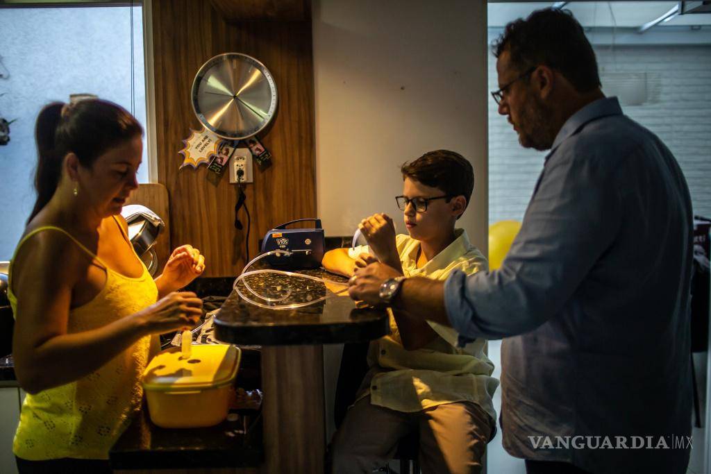 $!Rodrigo Rockenbach, de 11 años, que vive con fibrosis quística, usa un nebulizador mientras sus padres observan en Curitiba, Brasil.
