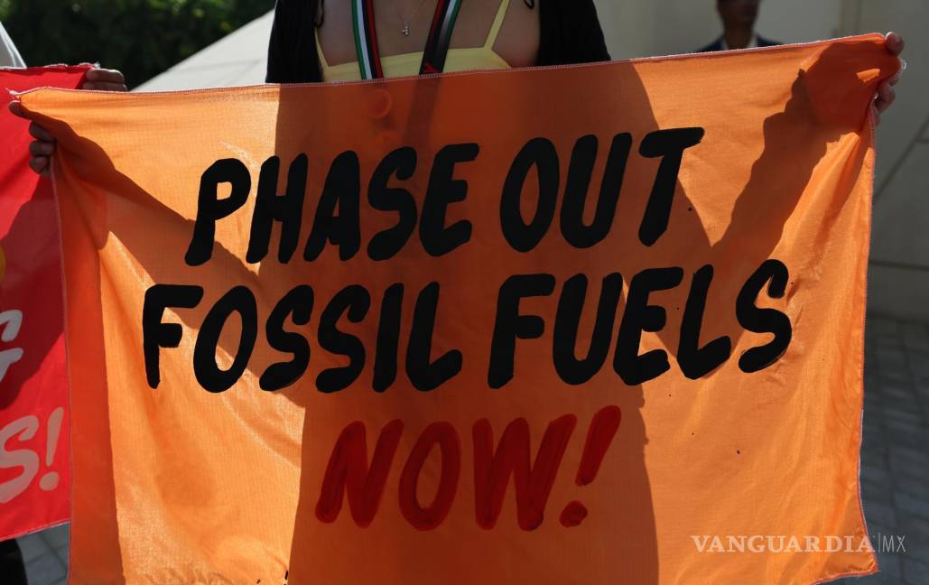$!Activistas sostienen pancartas y gritan consignas pidiendo energía renovable mientras asisten al quinto día de la COP28 en Dubai.